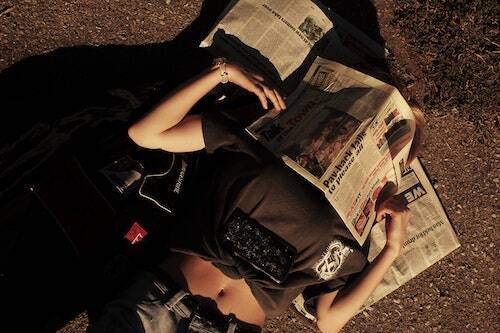 Woman in sun with newspaper