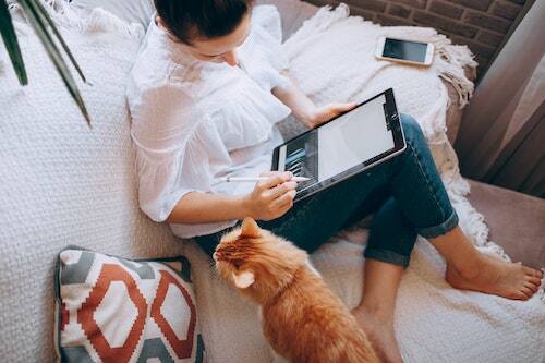 Woman with cat working on device