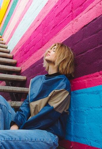 Woman leaning on colorful wall