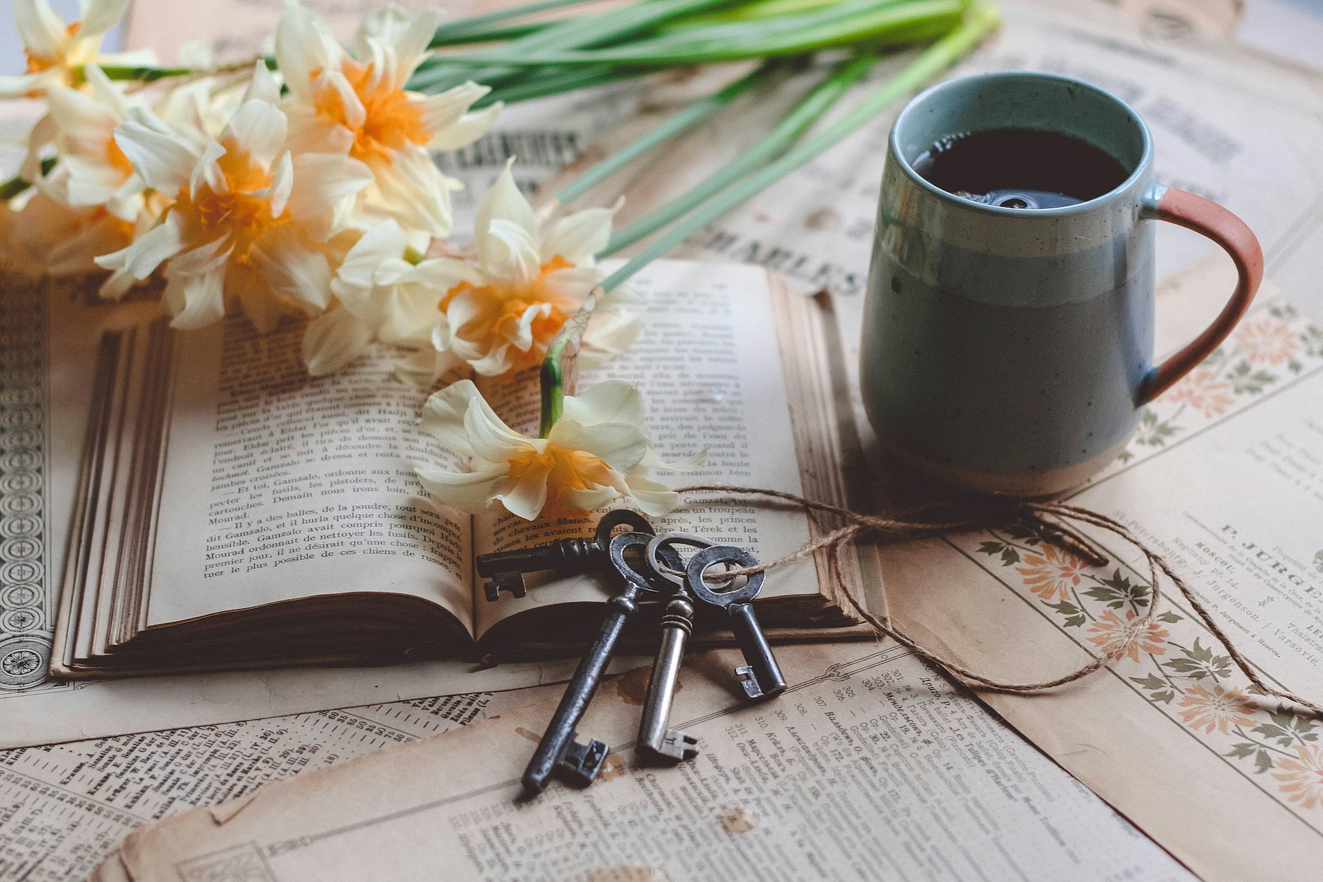 A book with keys resting on it and a mug beside it, symbolizing reflection, resilience, and unlocking the mindset needed to deal with rejection.