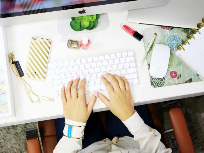 A person using a desktop computer, working on their content business.