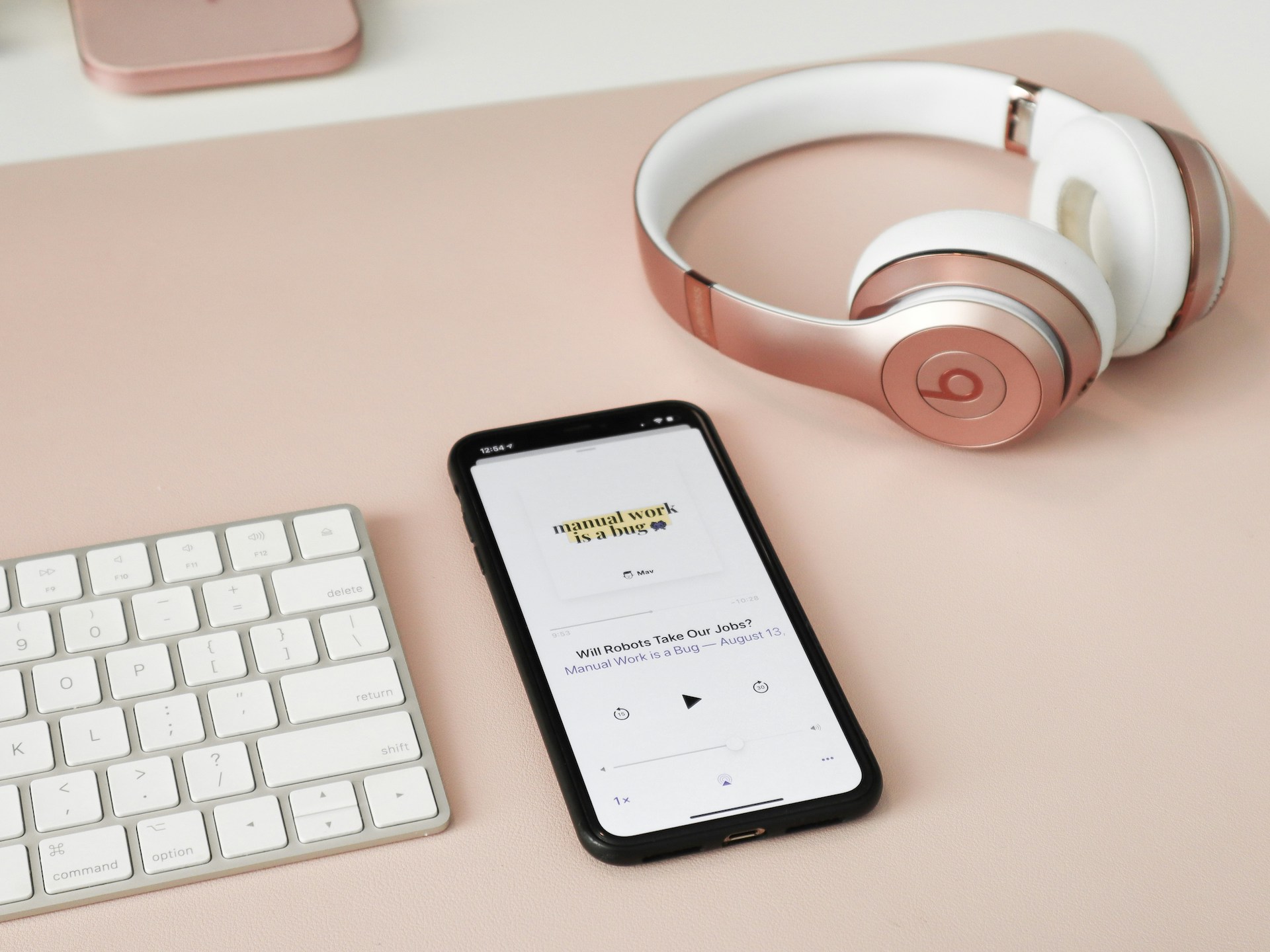 A black iPhone 5 next to white and red Beats by Dr. Dre headphones, tools of a creative entrepreneur.