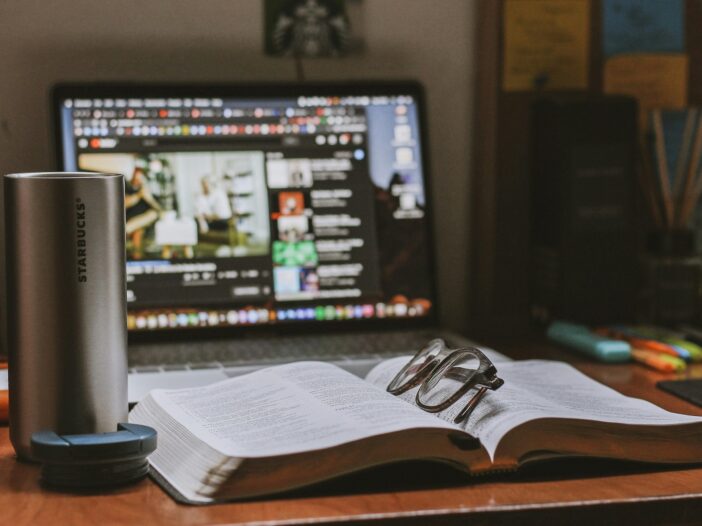 A coffee cup, notebook, and computer on a desk, representing the deep research and storytelling of long-form journalism.